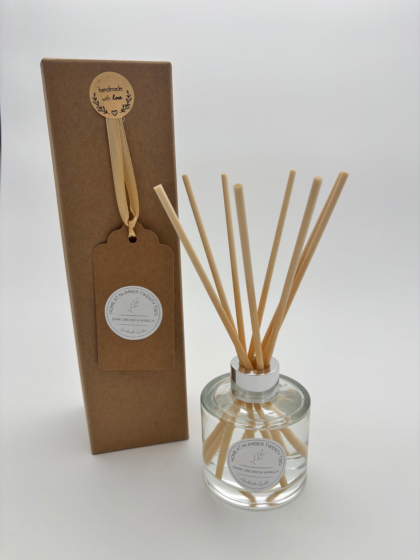 Dark Orchid and Vanilla Reed Diffuser in clear, glass bottle with silver cap and natural coloured reeds, alongside kraft Home at Number Twenty Two gift box