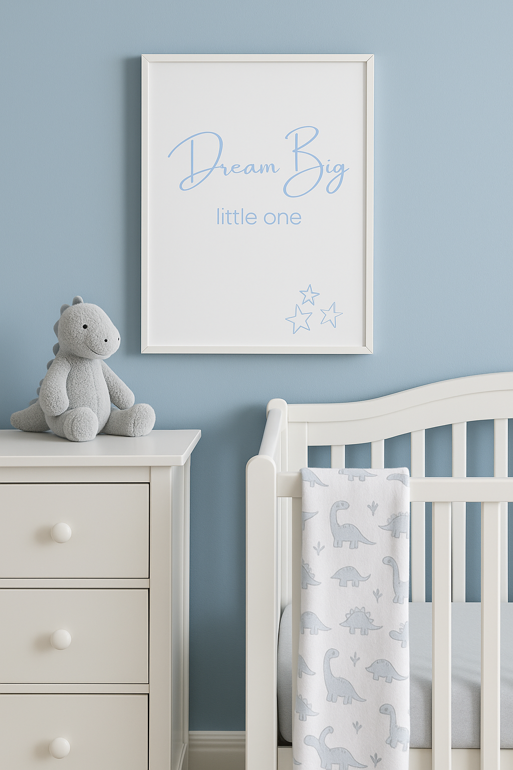 Dream Big Little One Nursery Wall Art in Pastel Blue shown above cot with dinosaur blanket