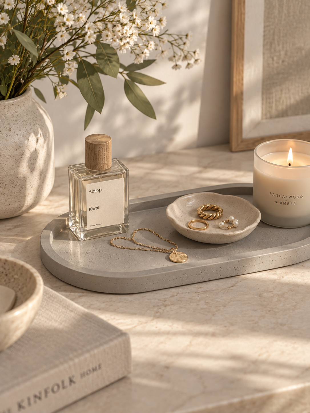 Grey Jesmonite trinket tray with perfume, jewellery and candle on a Scandi style console table
