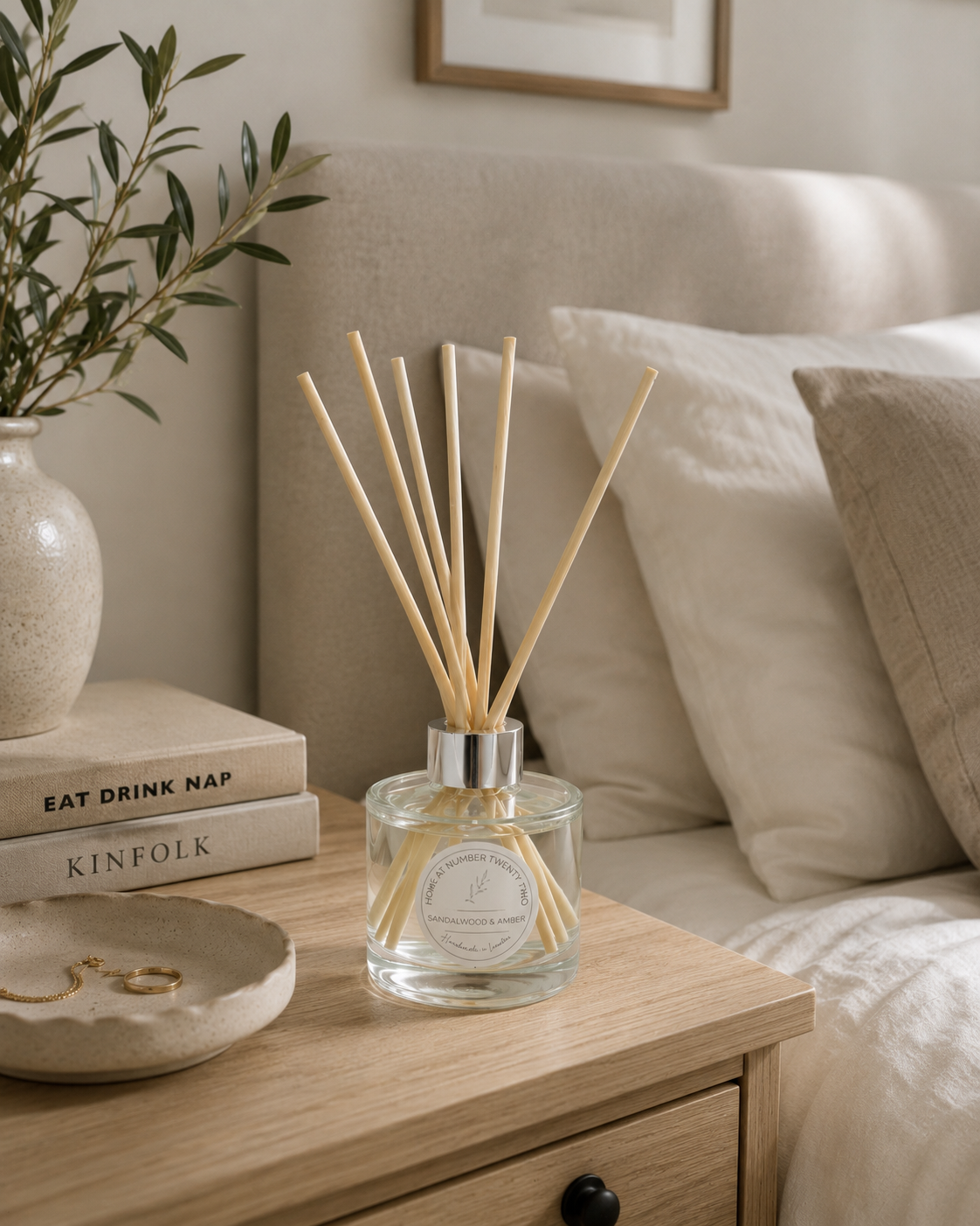 Sandalwood & Amber Reed Diffuser on a bedside table in a cosy bedroom, adding warm woody fragrance and elegant Scandinavian style.