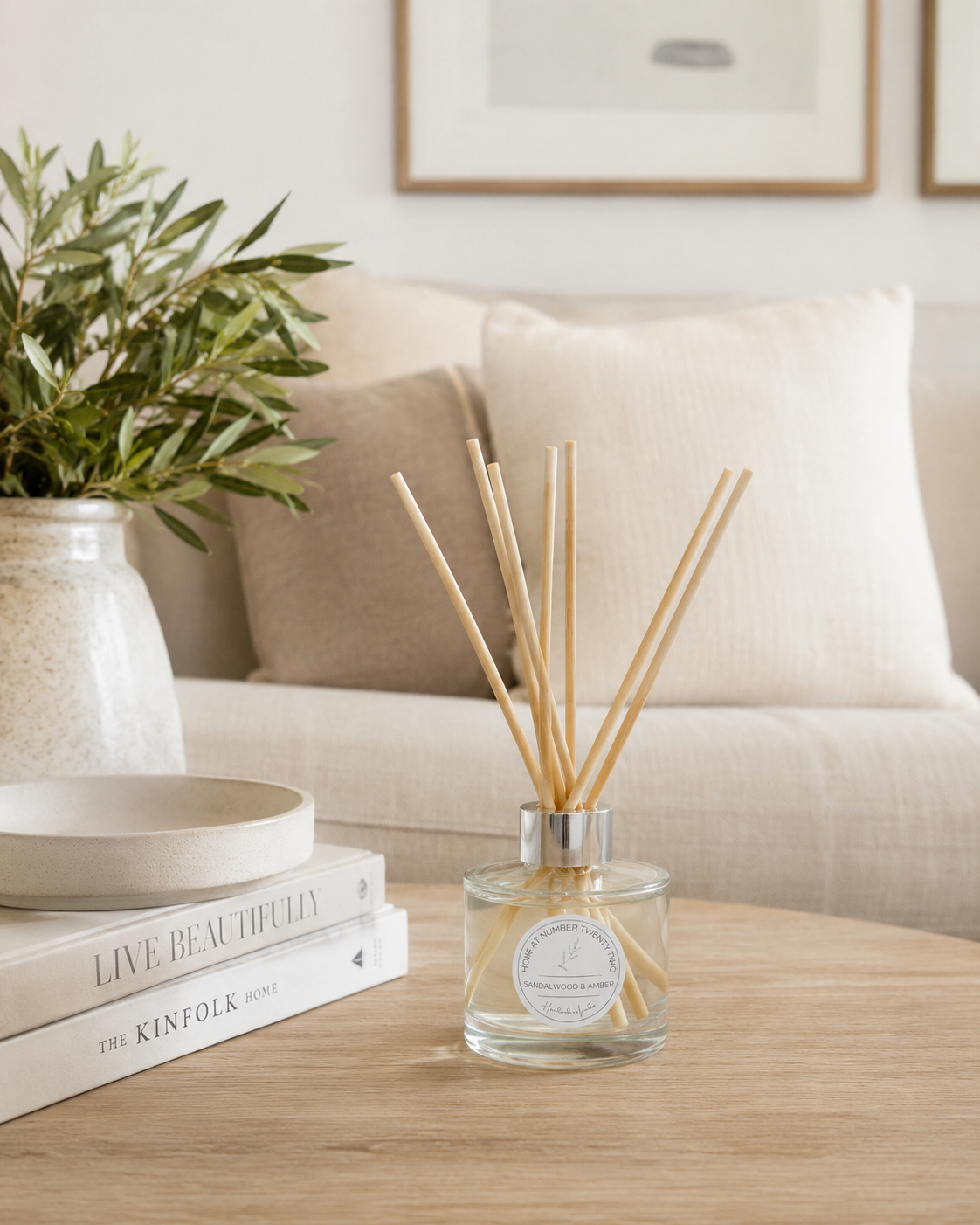 Handmade Sandalwood & Amber Reed Diffuser on a coffee table with neutral home décor, creating a relaxing and welcoming atmosphere.