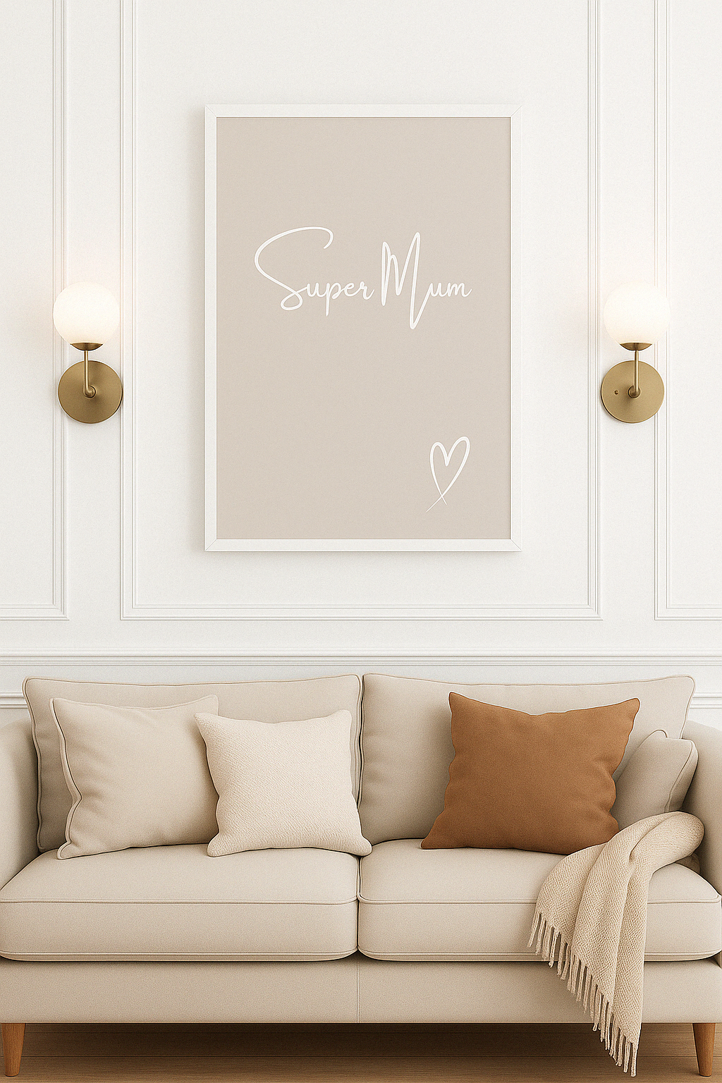 Beige sofa with decorative pillows and a framed print saying ''Super Mum'' in white calligraphy style font with a white hand-drawn heart, hung on a white panelled wall.