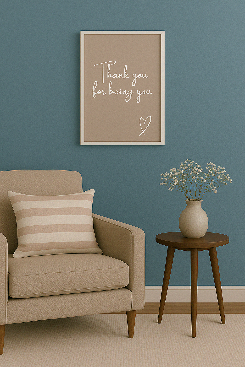 Beige armchair with a striped pillow, framed artwork ''Thank you for being you'', and small table with flowers against a blue wall.
