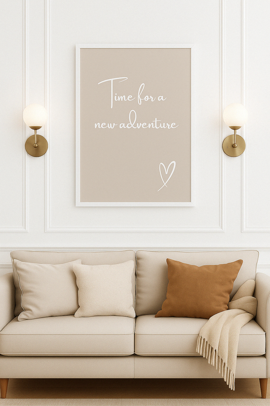 Beige sofa with pillows and a blanket, framed artwork on the wall with text 'Time for a new adventure'.