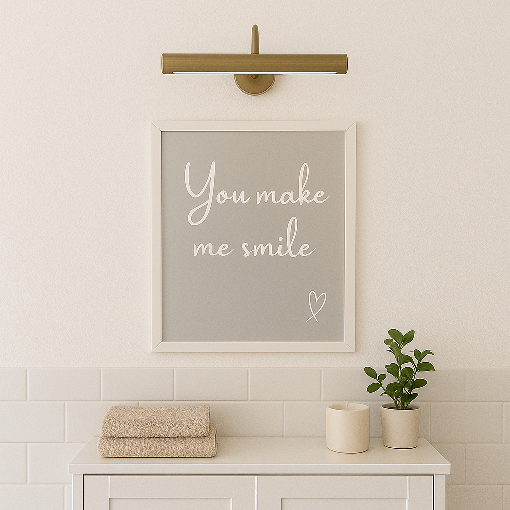 Framed artwork with 'You make me smile' text on a wall above a cabinet with towels and plants.
