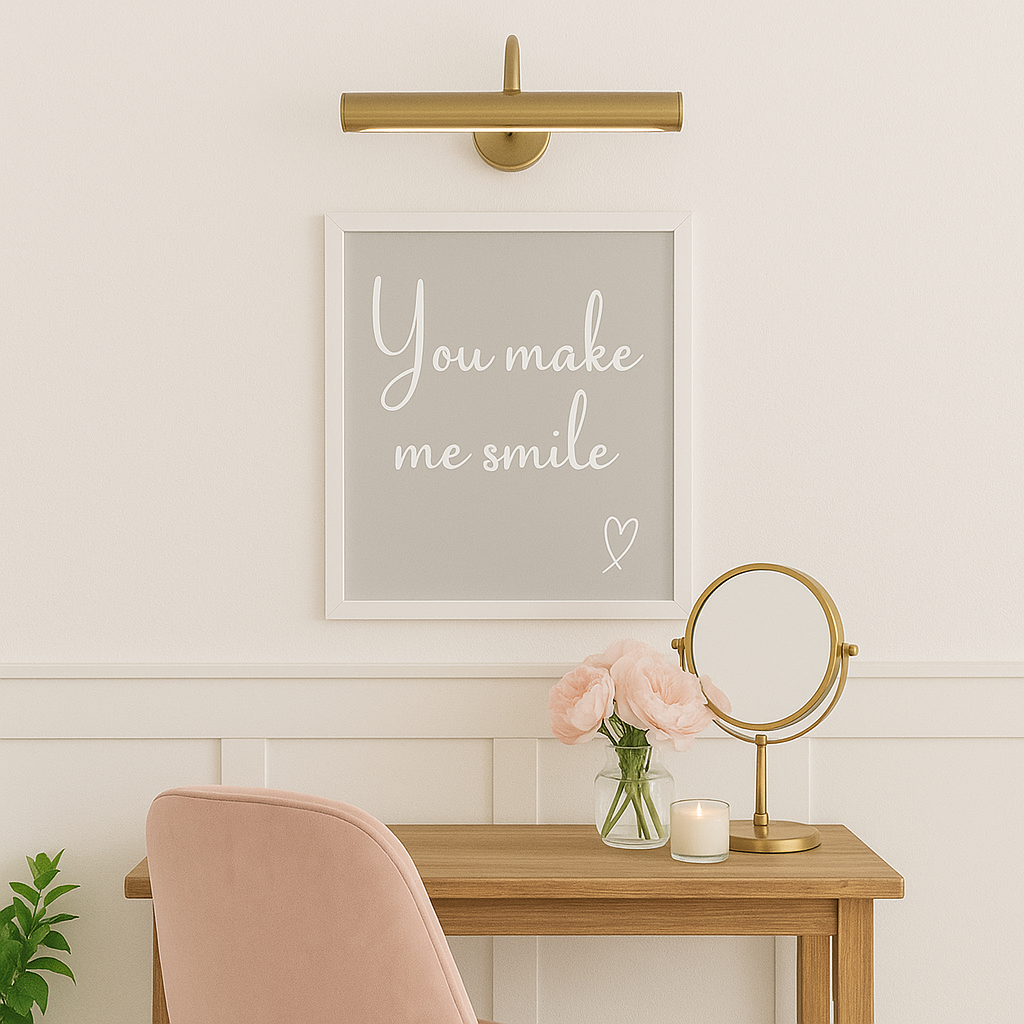Decorative setup with a framed quote 'you make me smile'', flowers, and candle on a table against a light wall.
