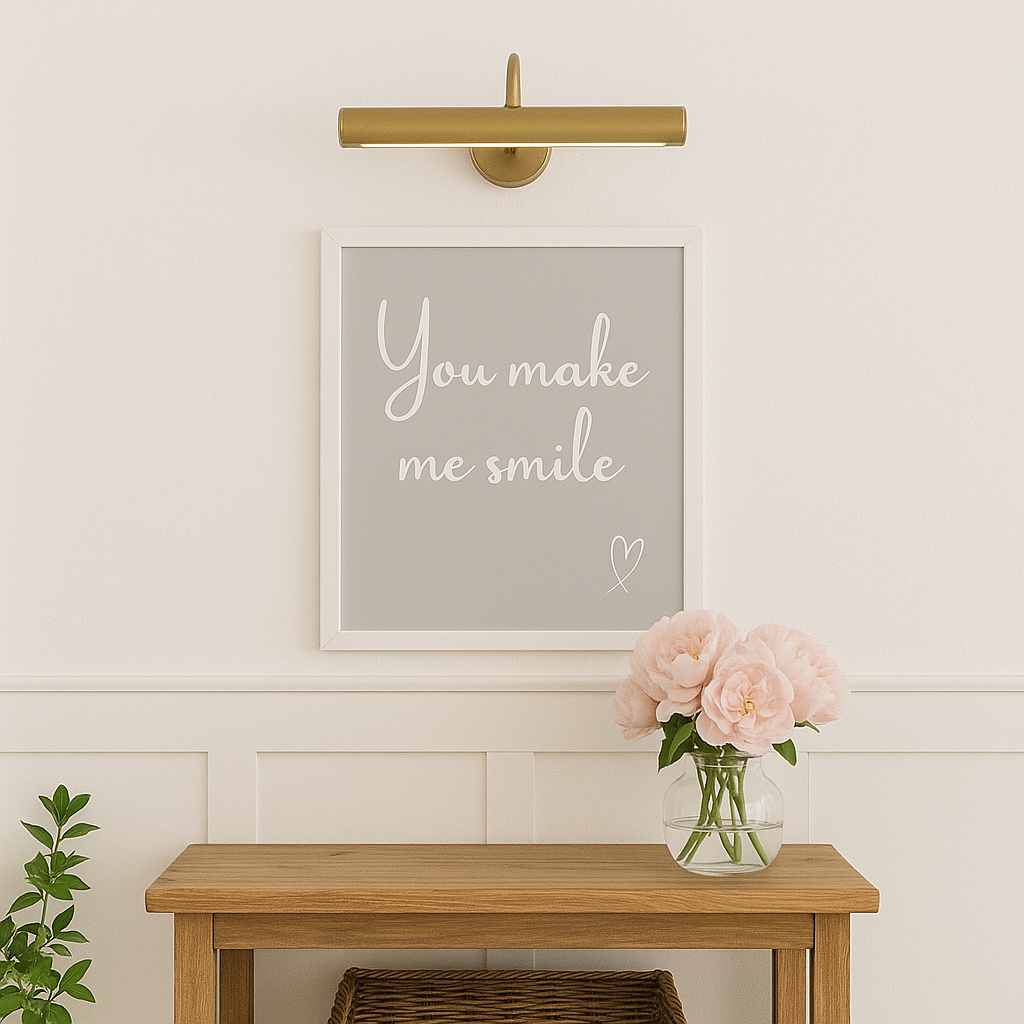 Decorative wall art with 'You make me smile' text on a light gray background, placed above a wooden table with flowers.