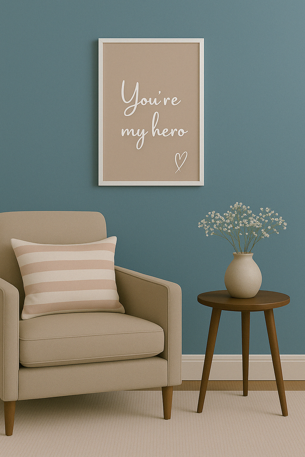 Beige armchair with striped pillow, small table with vase, and framed quote ''you're my hero'' on blue wall.